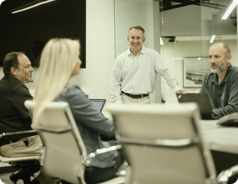 Scott Kowalchek, President and CEO of DirectAvenue, addresses coworkers in a meeting room setting.